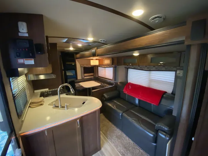 Spacious RV rental interior with a bright kitchen, cozy dinette, and comfortable couch, perfect for travel adventures.. Dutchmen Aerolite 2017