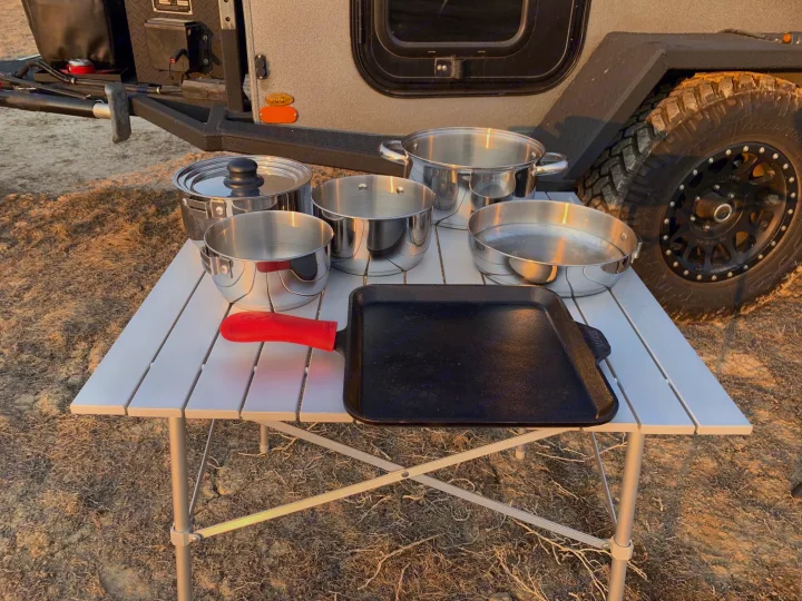 Essential camping cooking gear: pots, pans, and a griddle on a table, perfect for your RV rental outdoor kitchen.. Little Guy Silver Shadow 2015