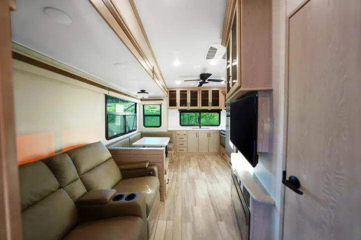 Modern RV rental interior: living area with recliner sofa, dining booth, full kitchen, & entertainment unit. Bright & spacious.. Forest River Other 2022