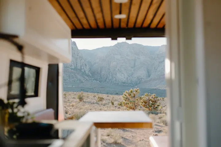 An RV rental provides an unforgettable view: desert flora leading to grand, rocky mountains bathed in soft light.. Dodge Sprinter 2019
