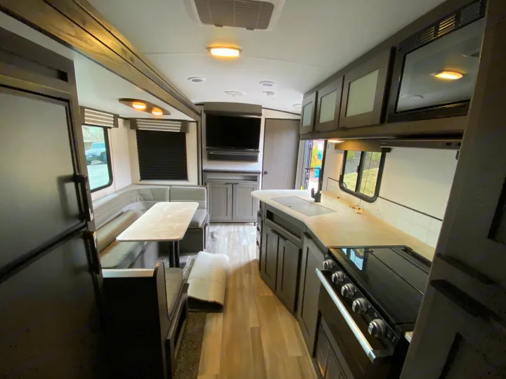 Explore this modern RV rental's spacious interior: full kitchen, cozy U-shaped dinette, entertainment, and ample storage.. Cruiser RV MPG Ultra Lite 2500BH 2021