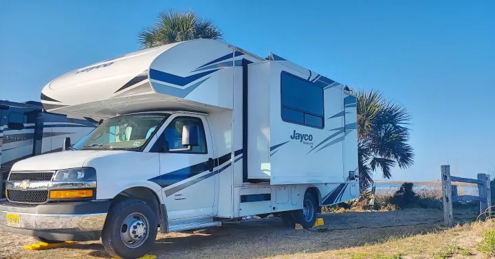 This white Jayco Redhawk SE Class C RV rental is perfectly parked at a sunny beachside campsite, ready for adventure.. Jayco Redhawk 2020