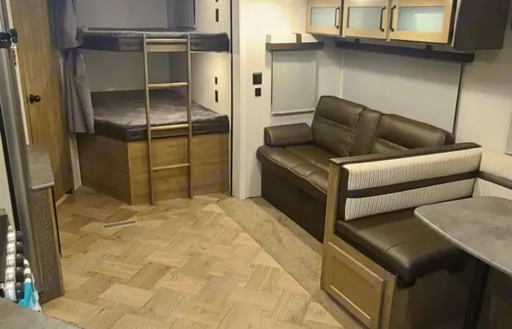 Spacious RV rental with bunk beds, a leather sofa, and a dinette. Bright, comfortable interior for adventures.. Palomino Puma 28DBFQ 2021