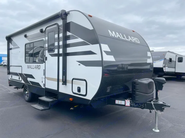 A sleek, black and white travel trailer, ready for your next RV rental. Features a modern exterior with an extended awning.. Heartland Mallard 180BH 2022