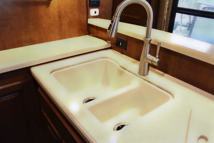 RV rental kitchen: bright double sink, modern pull-down faucet, light speckled countertops for comfortable trips.. Thor Challenger 2015