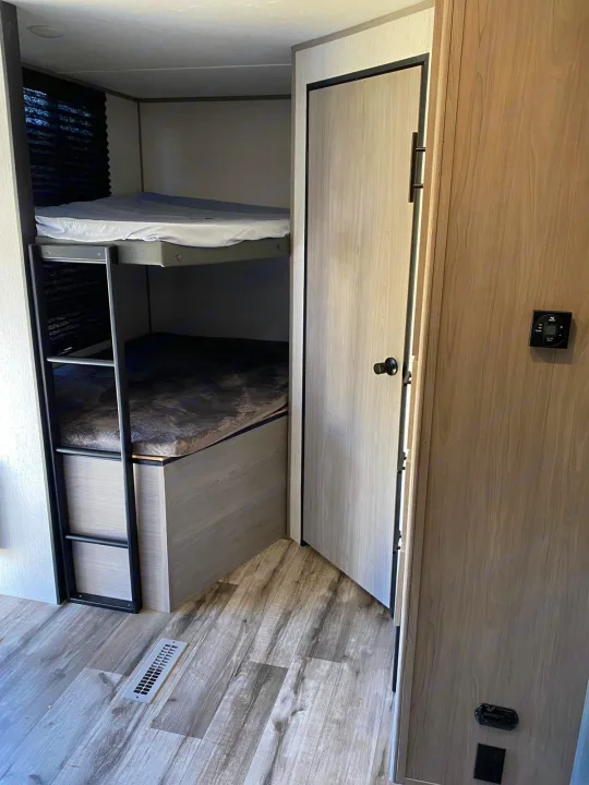 Compact RV rental interior featuring two bunk beds, ideal for efficient sleeping.. Dutchmen Coleman 2022