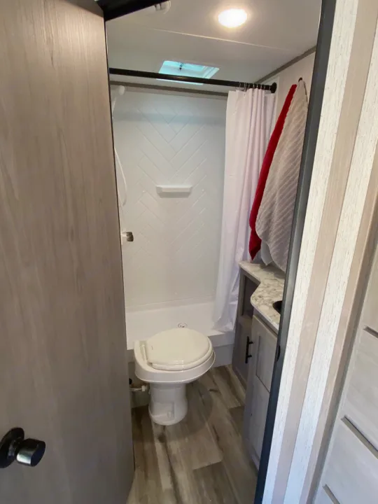 Compact RV rental bathroom with toilet, shower, and vanity. Perfect for travel convenience.. Dutchmen Coleman 2022