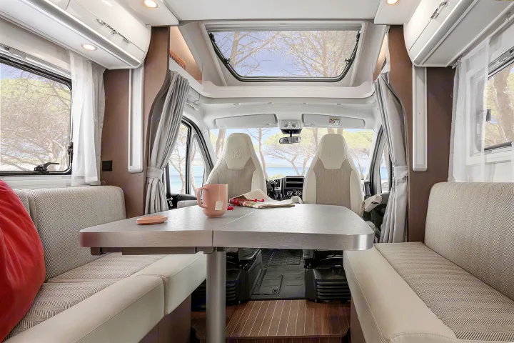 Explore this bright RV rental interior: a dining area, cockpit, and scenic views through large windows create a welcoming space.. Etrusco Etrusco T7400SBC 2021