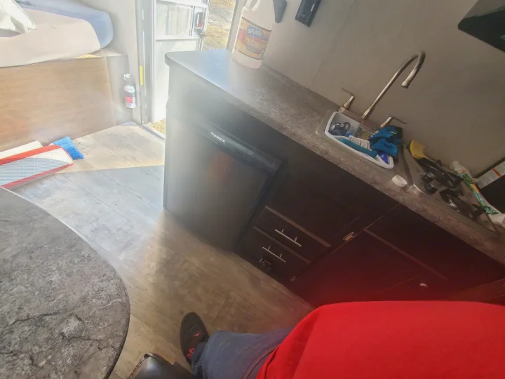 Inside an RV rental: kitchen with Dometic fridge, sink & stove, cozy bed, and essential safety gear. Ready for adventure!. Heartland RVs Pioneer 2020
