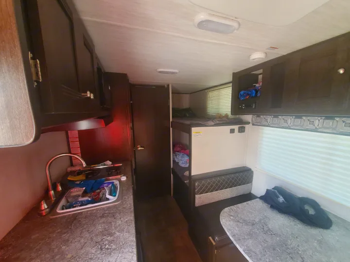 Spacious RV rental interior featuring a kitchen, bunk beds, and dinette area, perfect for family travel.. Heartland RVs Pioneer 2020