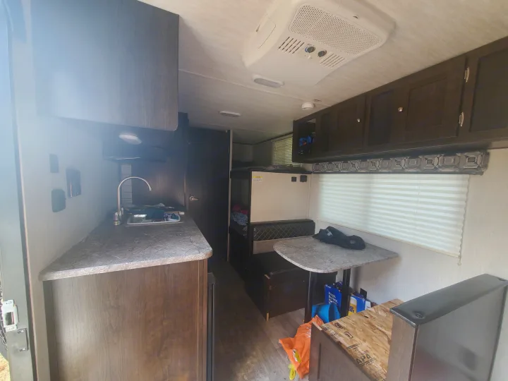 Inside an RV rental: full kitchen, dining nook, and bunk beds. Your cozy home on wheels for travel.. Heartland RVs Pioneer 2020