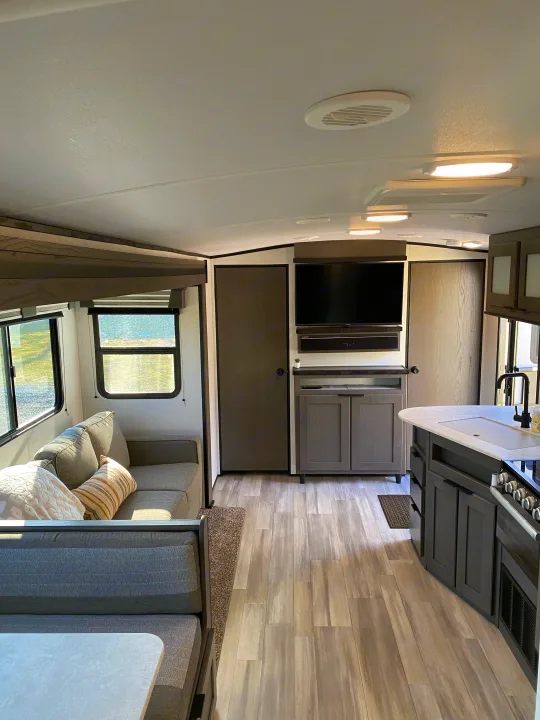 Bright and modern rv rental interior featuring a cozy living space, equipped kitchen, and comfortable dinette area.. Cruiser RV MPG Ultra Lite 2021