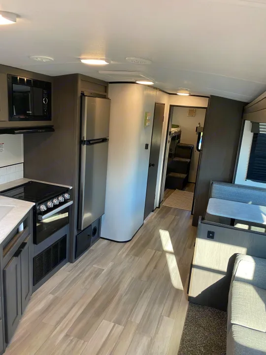 Bright and modern RV rental interior showing kitchen, dinette, and hallway to sleeping quarters. Ideal for travelers.. Cruiser RV MPG Ultra Lite 2021