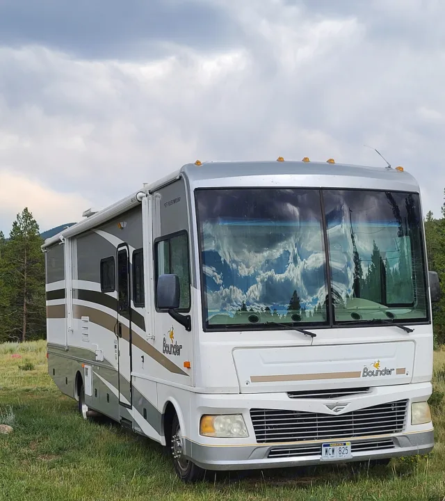 A spacious RV rental, a Fleetwood Bounder, parked in a grassy outdoor setting under cloudy skies.. Fleetwood Other 2006