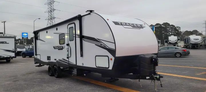 New white Prime Time Tracer LE Ultra-Lite travel trailer on a dealership lot, ideal for an RV rental.. Forest River Tracer 2022