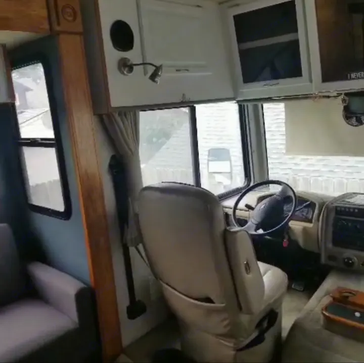 Explore this spacious RV rental interior! Features a driver's cockpit, swivel seat, and comfortable living space. Ready for the road.. Fleetwood Other 2006