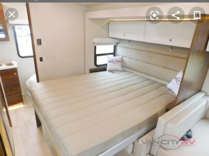 RV rental interior: comfy bed with storage cabinets & small sink. Perfect for your next road trip!. Winnebago Navion 2020