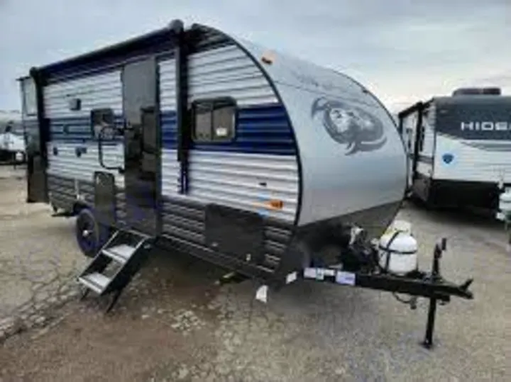 This silver/blue travel trailer, ideal for RV rental & camping trips, offers comfortable lodging options.. Forest River Wolf Pup 2020