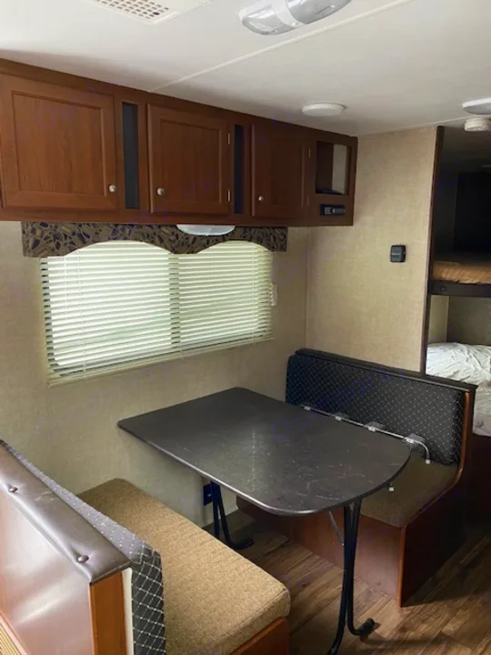 RV rental: RV interior, showing a dinette area with table & upholstered benches, adjacent to built-in storage cabinets.. prowler lynx 22LX 2015