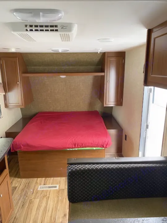 RV rental interior showcasing a sleeping area with red bed, ample storage, and wall amenities for comfort.. prowler lynx 22LX 2015