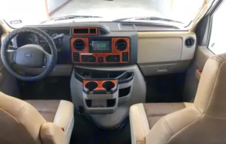 RV rental: Motorhome cockpit showing a bright dashboard, steering wheel, and front seats, ready for your road trip.. Forest River Coachmen Leprechaun 2018