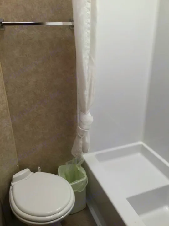 Compact RV rental bathroom: features a toilet, shower curtain, & small basin, optimizing space.. Adventurer 31DS 2014