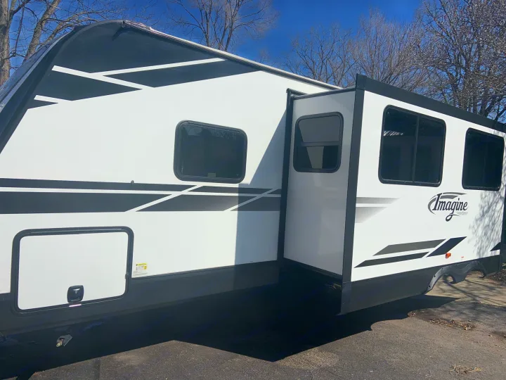 This white Imagine RV rental, with its side slide-out extended, awaits your next outdoor travel adventure.. Grand Design 2800BH 2021