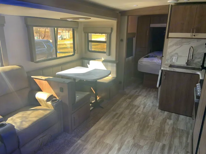 Spacious rv rental interior with living, dining, kitchen, and bedroom areas visible. Modern amenities for travel.. Grand Design 2800BH 2021