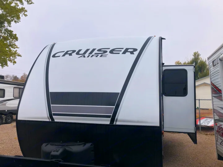Front view of a white Cruiser Aire travel trailer with black and grey graphics, ready for your RV rental.. Crossroads Cruiser Aire 2021