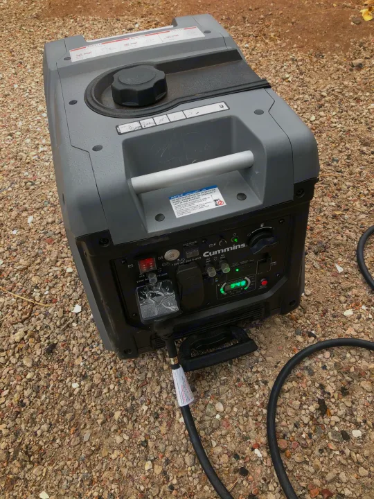 RV rental essential: Cummins inverter generator on gravel, providing reliable outdoor power.. Crossroads Cruiser Aire 2021