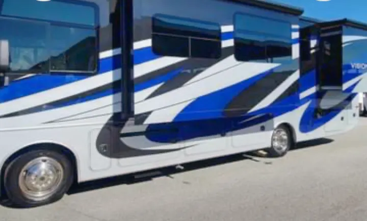 Spacious white RV rental with dynamic blue & black graphics & extended slide-outs, parked on pavement.. Ford Motorhome Chassis 2020