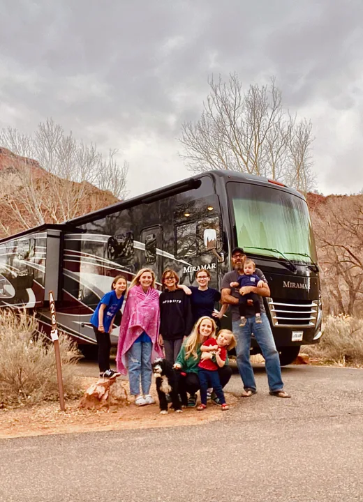 Family, kids, and dog smile by their Miramar RV rental at a scenic campsite.. Thor 37.1 2022