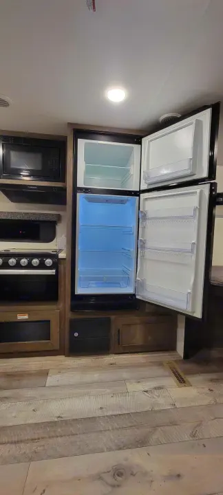RV rental kitchen: Microwave, stove, oven, and open refrigerator for easy travel.. Sportsmen SE 2021