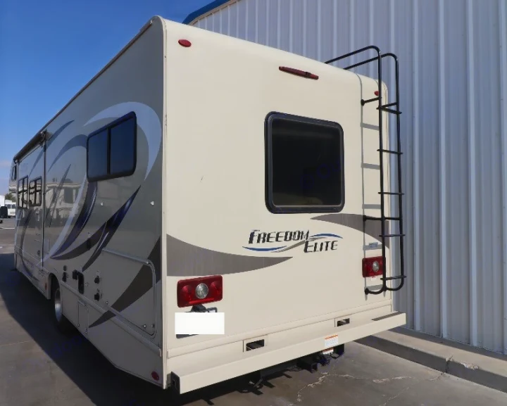 Rear and side view of a tan "Freedom Elite" RV, featuring a ladder, graphics, and a rear window. This motorhome is perfect for an rv rental.. Thor Freedom Elite 2019