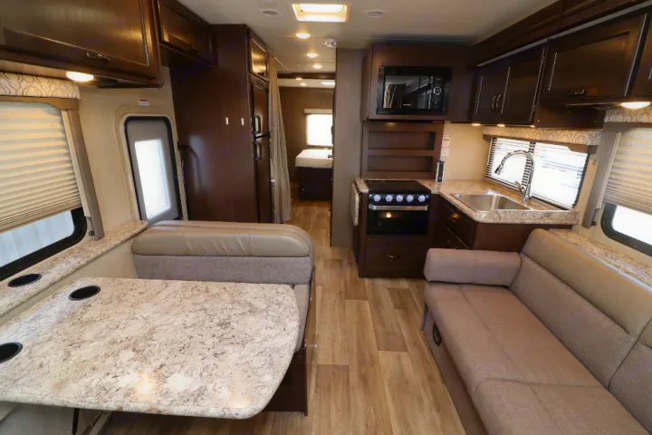 Explore this clean RV rental interior: kitchen, dinette, sofa, and bedroom access. Your mobile home awaits!. Thor Freedom Elite 2019