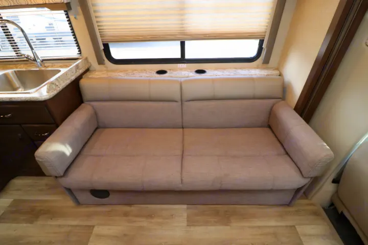 RV rental: Relax in this comfortable living area with a sofa, kitchen sink, & counter with cupholders.. Thor Freedom Elite 2019