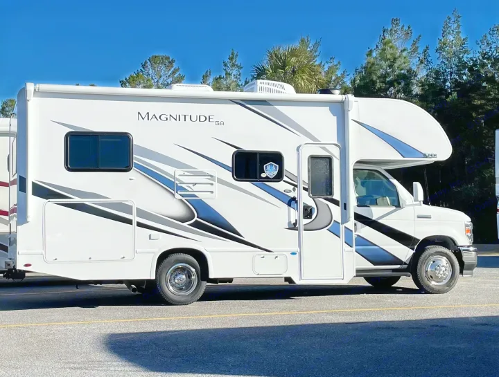White Thor Magnitude Class C RV rental with bold graphics, parked in sunlight. Perfect for road trips.. Thor Magnitude GA22 2022
