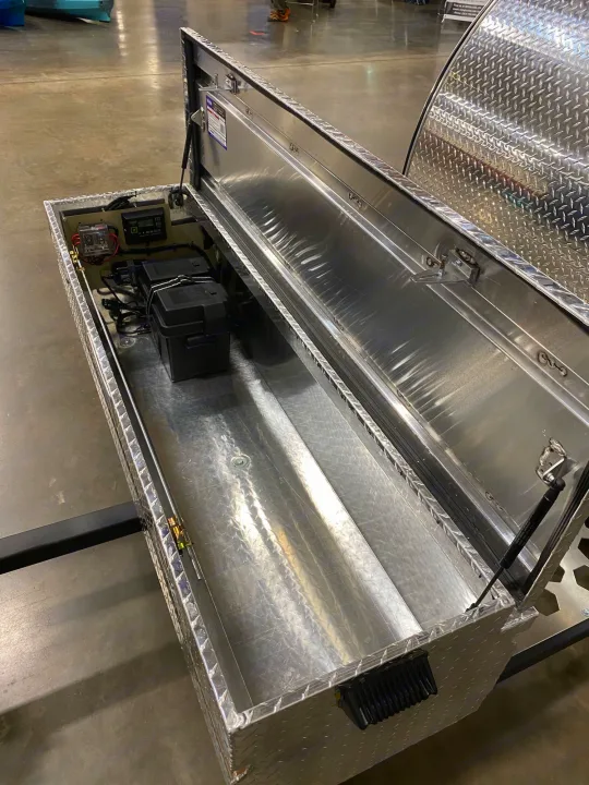 RV rental auxiliary power box: open diamond-plate aluminum utility box revealing batteries and electrical setup.. TC Tear Drop TC Original 2022