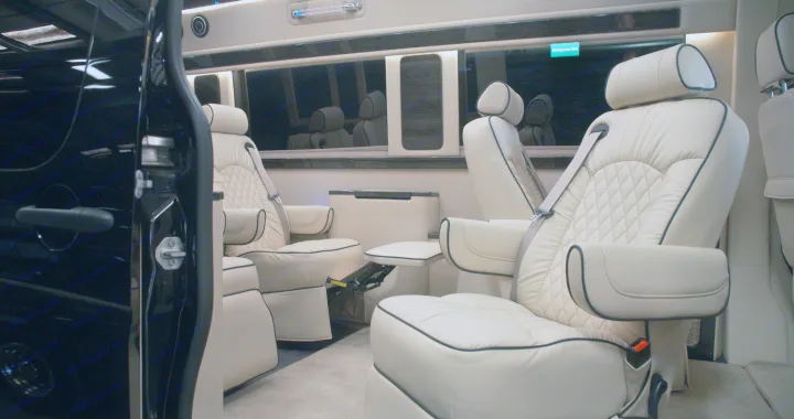Luxurious RV rental interior with cream quilted leather seats and footrests, offering premium comfort for spacious travel.. Ultimate Toys Ultimate Coach 2022