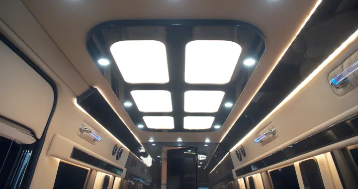 Luxurious RV rental interior with modern ceiling lights, ambient strip lighting, and upscale finishes for comfortable travel.. Ultimate Toys Ultimate Coach 2022