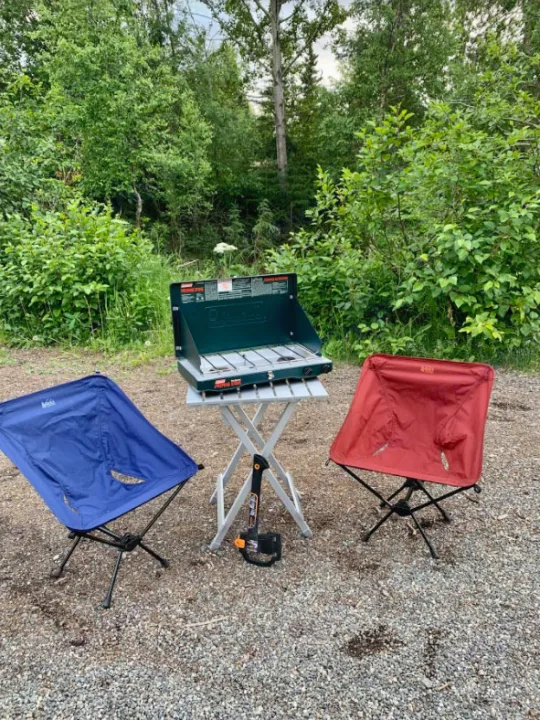 RV rental campsite: Coleman stove, REI chairs & axe on gravel. Ready for outdoor cooking.. Dodge Ram 2500 (Class B) 2021