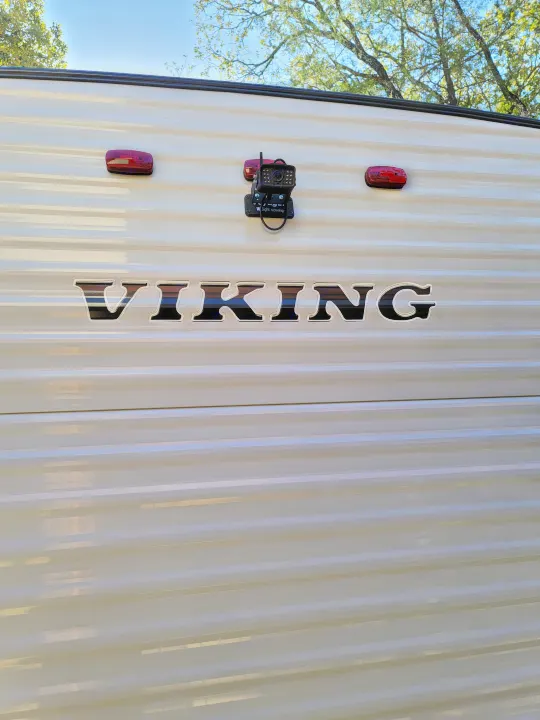 RV rental side with 'VIKING' branding, a side-mounted camera, and marker lights. Perfect for travel!. Coachmen Viking 2019