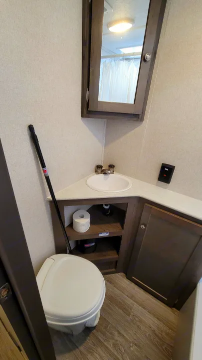 Step into this cozy RV rental bathroom. Features: compact sink, toilet, mirrored cabinet, and essential amenities.. Coachmen Viking 2019