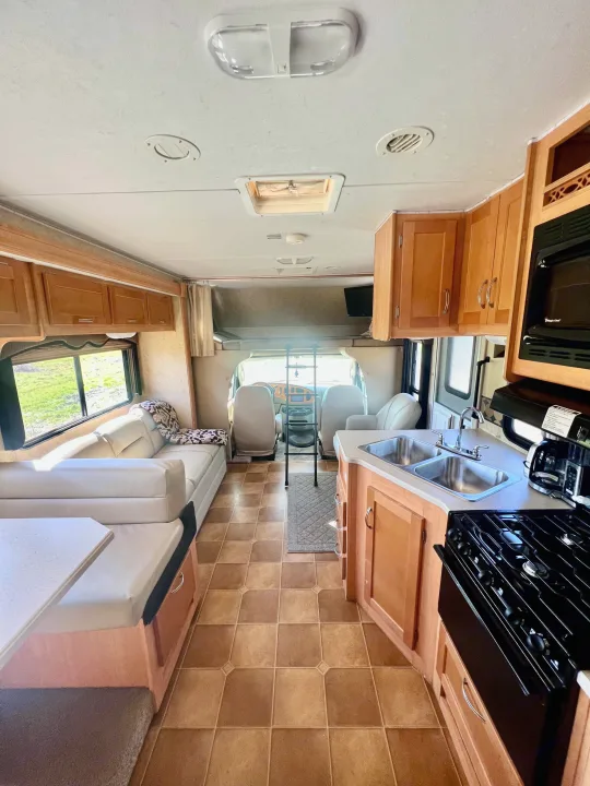 Clean rv rental interior: full kitchen, dinette, couch, and overhead bunk provide comfort for your next road trip.. Forest River Sunseeker 2009