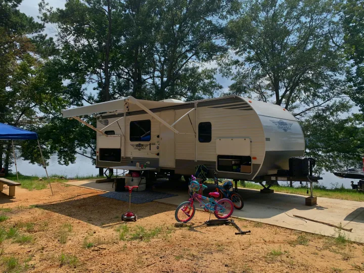 Perfect RV rental setup! Travel trailer lakeside campsite with awning, bikes, and water views for a relaxing outdoor stay.. Shasta 25RS 2021