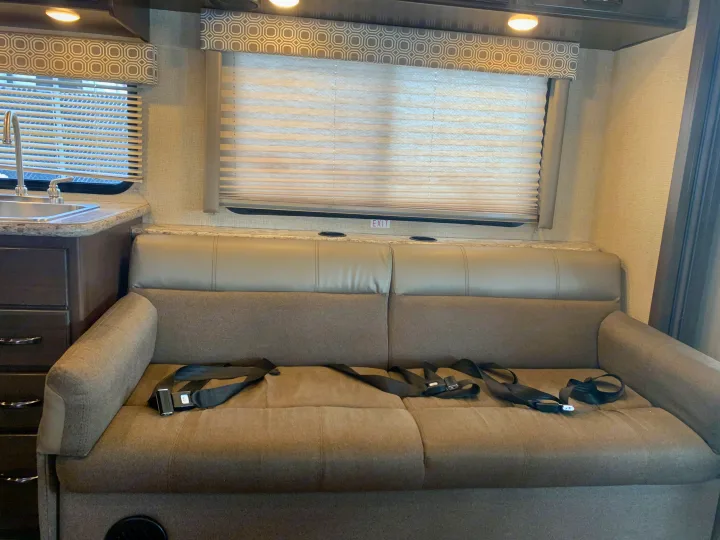 RV rental: View of the living area with a sofa, seatbelts, window blinds, and adjacent kitchen sink.. Thor Motor Coach Four Winds 2019