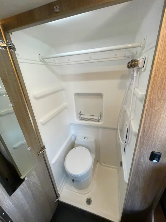 RV rental interior: A compact wet bath with shower, toilet, and integrated storage, designed for efficiency.. Winnebago solis 2022