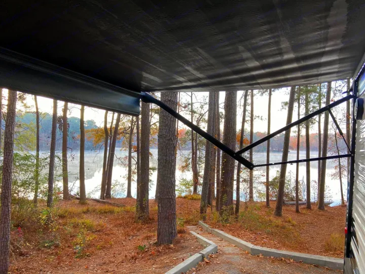 RV rental campsite view: serene lake through autumn trees from under the awning. Great camping spot.. Clipper Other 2021