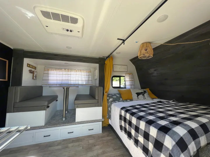 Cozy RV rental interior featuring a comfortable bed, dinette, and modern decor, ideal for a relaxing travel experience.. Keystone RV Hideout 2022