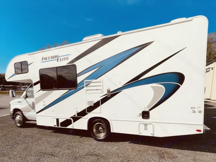 This white Freedom Elite RV rental, adorned with striking blue and black graphics, is ready for your next adventure.. Thor Freedom Elite 2021